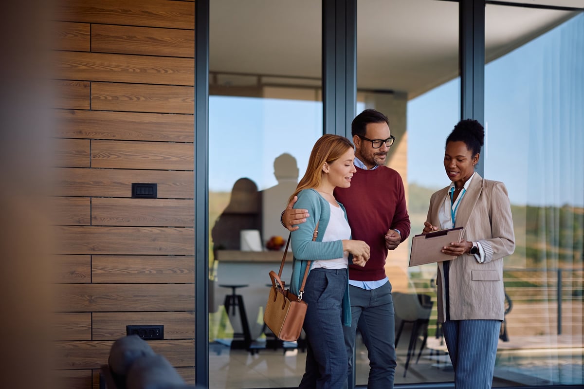 Real estate professional reviewing a home plan with a young couple