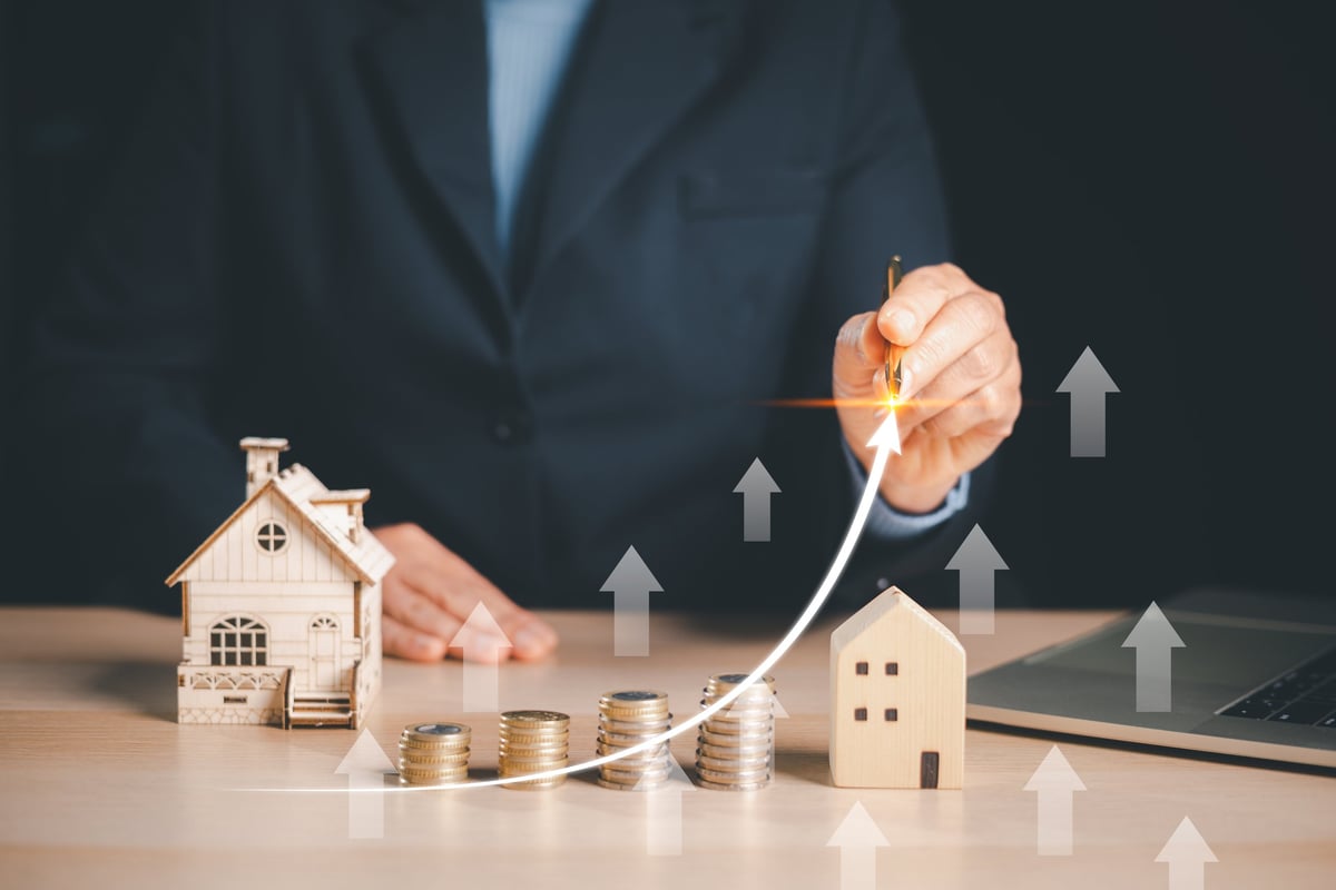 Real estate investment growth represented by a rising arrow over a house model